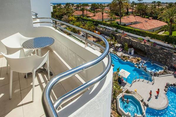 Oberblick auf den Balkon des Abora Catarina Hotel mit Tisch und Stühlen, Blick auf den Swimmingpool.
