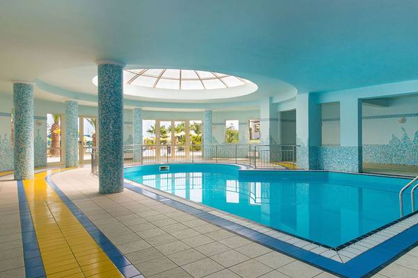 Innenpool des Iberostar Creta Marine Hotels mit blauen Wänden und einer Glaskuppel.
