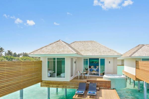 Außenansicht der Wasservilla im Kandima Maldives Hotel mit Whirlpool und Sonnenliegen