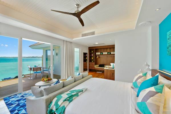 Innenansicht der Suite im Kandima Maldives Hotel mit Blick auf das Meer und modernem Interieur.