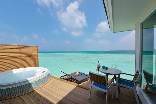 Ein Balkon mit einem Whirlpool und Meerblick im Kandima Maldives Hotel.