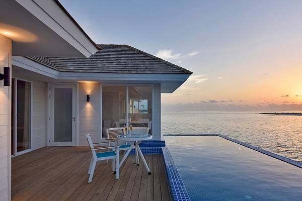 Aussicht auf das Meer von der Villa im Kandima Maldives mit einem Tisch und Stühlen auf der Terrasse.