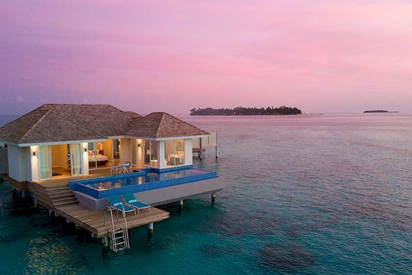 Außenansicht der Wasservilla im Kandima Maldives Hotel mit Pool und Sonnendeck.