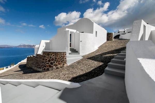 Außenansicht des Ambassador Aegean Luxury Hotel & Suites mit weißen Wänden und einer Aussicht auf das Meer.