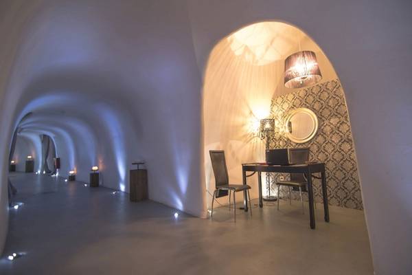 Arbeitszimmer im Ambassador Aegean Luxury Hotel & Suites mit Schreibtisch, Stühlen und Wanddekoration.