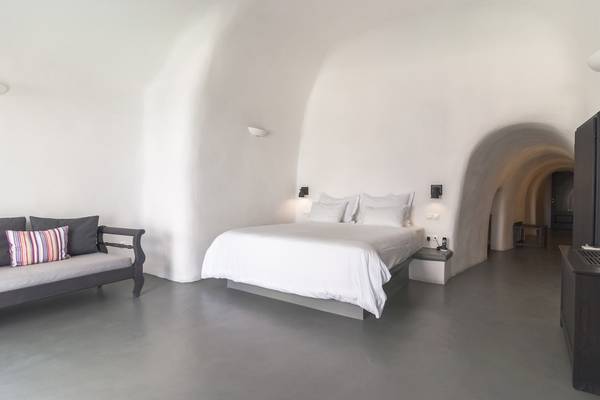 Schlafzimmer im Ambassador Aegean Luxury Hotel & Suites mit einem Bett, Kissen, und einer Couch