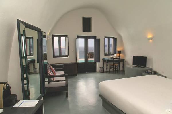 Innenansicht eines Schlafzimmers im Ambassador Aegean Hotel mit Bett, Spiegel, Möbeln und Meerblick