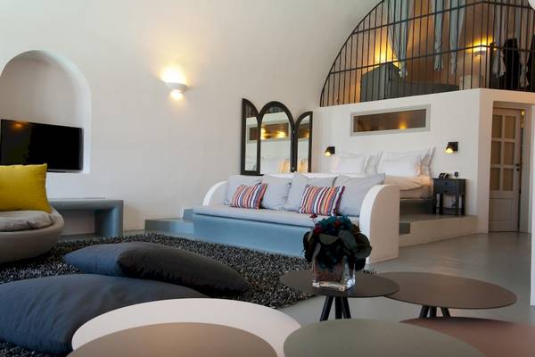 Schlafzimmer im Ambassador Aegean Luxury Hotel mit Bett, Fernseher und vielen Kissen