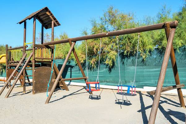 Spielplatz im Iberostar Creta Marine Hotel mit Schaukeln und einer Rutsche.
