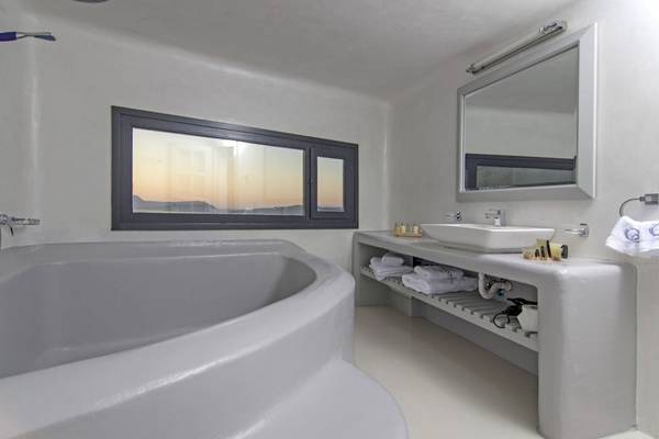 Badezimmer im Ambassador Aegean Luxury Hotel & Suites mit Badewanne, Waschbecken und Fenster.