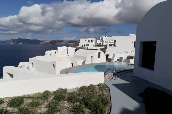 Blick auf ein weisses Hotel mit Swimmingpool und Meer in der Ferne