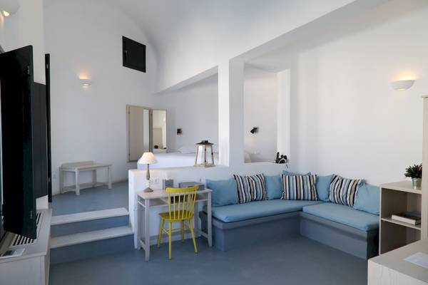 Innenraum des Ambassador Aegean Luxury Hotel & Suites mit Sofa, Schreibtisch und Fernseher.