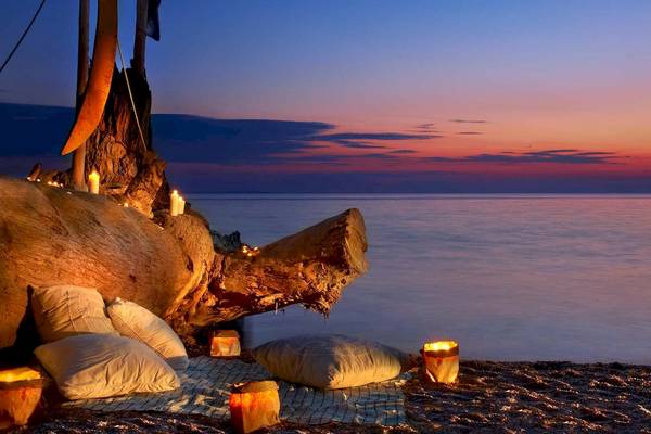 Romantisches Strandpicknick am Abend bei Acrotel Athena Pallas mit Kerzen und Kissen.