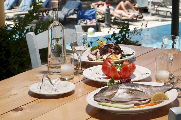 Ein Tisch am Pool des Acrotel Athena Pallas Hotels mit Fisch, Tomaten und Salaten.