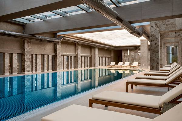 Der Pool- und Loungebereich des Hotels Acanthus Cennet Barut Collection mit Liegestühlen und Glasdach.