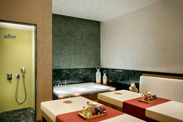 Spa-Behandlungsraum im Acanthes Cennet Barut Collection Hotel mit Badewanne, Massagetischen und Dekoration.