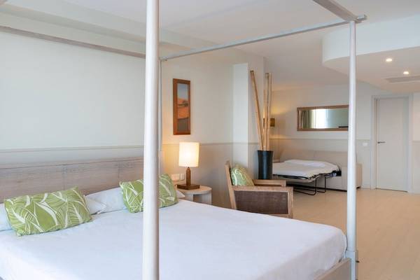Doppelbett Zimmer im Vincci Tenerife Golf Hotel mit vier weißen Säulen, weißen Wänden und grünen Kissen.