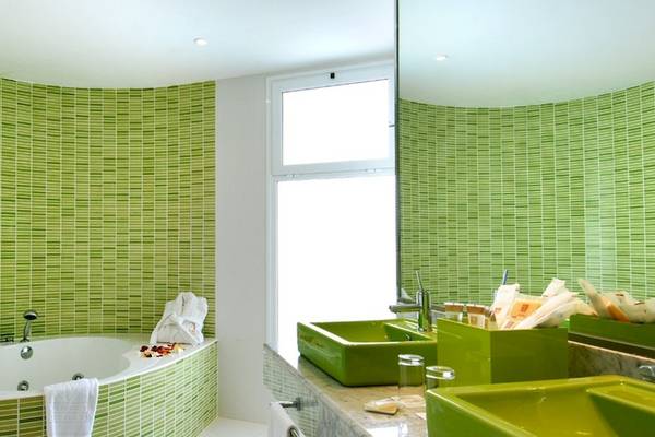 Badezimmer im Vincci Tenerife Golf Hotel mit grünen Wänden, Badewanne und grünen Waschbecken.
