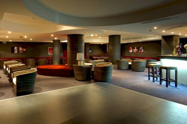 Loungebereich im Vincci Tenerife Golf Hotel mit roten Sofas, Stühlen und einer Bar.