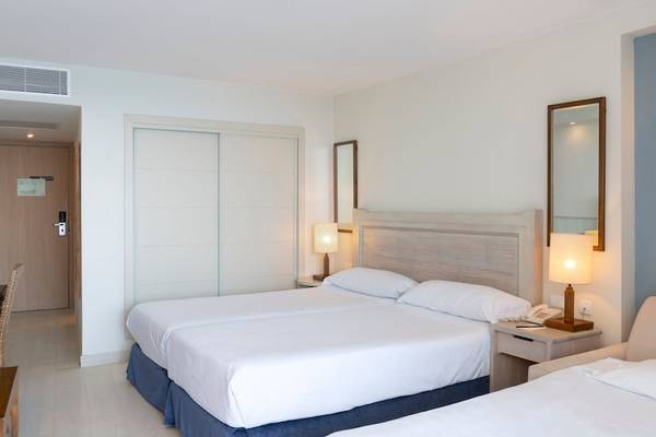 Doppelzimmer im Vincci Tenerife Golf Hotel mit zwei Betten, Nachttischen, Lampen und einem Sofa.