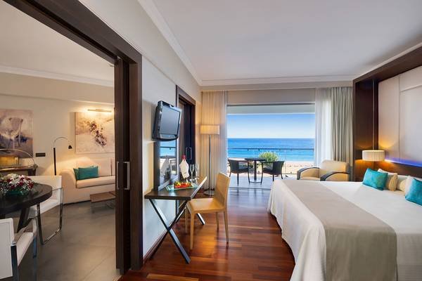 Elysium Resort & Spa Suite mit Meerblick, Bett, Schreibtisch und Balkonmöbeln.