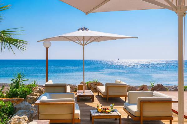 Terrasse mit Sofas unter einem Umbrella mit Blick auf das Meer