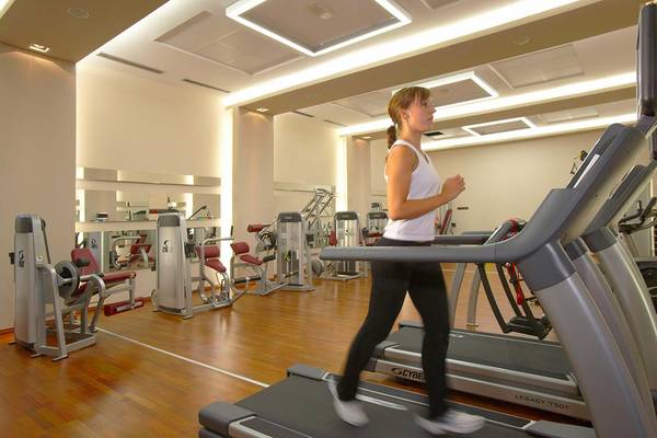 Eine Frau läuft auf einem Laufband im Fitnessstudio des Elysium Resort & Spa.