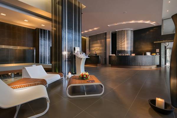 Lobby des Elysium Resort & Spa mit modernen Möbeln, einem Empfangstresen und einer Wasserwand.
