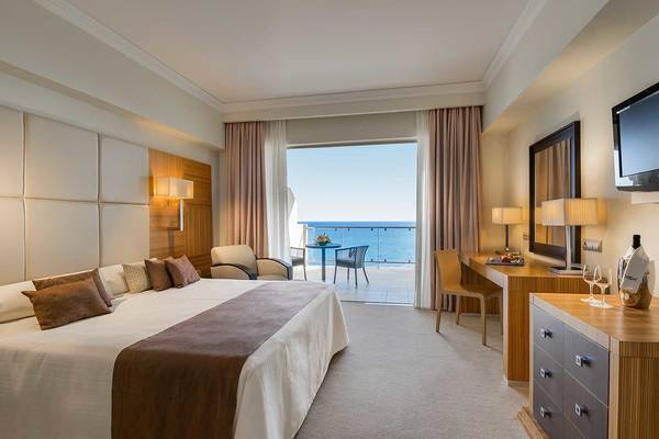 Elysium Resort & Spa Schlafzimmer mit Meerblick, inklusive Bett, Schreibtisch und Balkon.