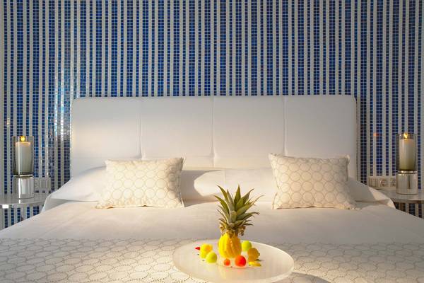 Bett im Elysium Resort & Spa mit Ananas auf Glasplatte und blau gefliester Wand