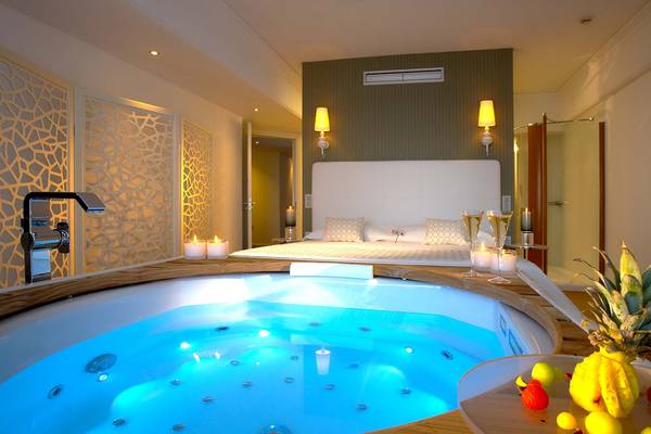 Jacuzzi im Schlafzimmer des Elysium Resort & Spa mit Früchten und Champagner