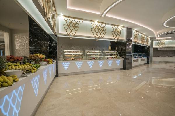 Innenansicht des Buffets im Adalya Elite Lara Hotel mit Obst und Desserts.