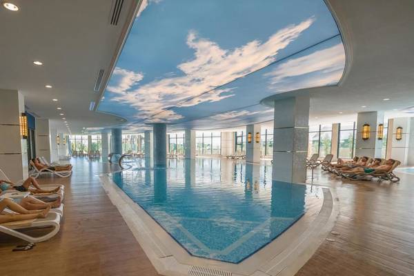 Innenpool im Adalya Elite Lara Hotel mit Sonnenhimmeldecke und Liegestühlen