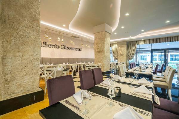 Innenansicht des Restaurants im Adalya Elite Lara Hotel mit gedeckten Tischen und Stühlen.