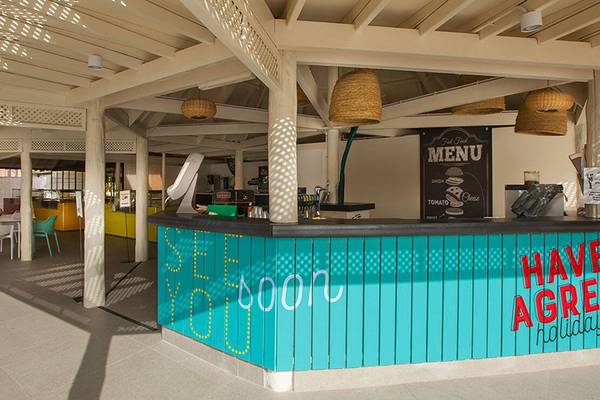 Innenansicht der Bar des Abora Continental by Lopesan Hotels mit bunten Stühlen und Tischen.
