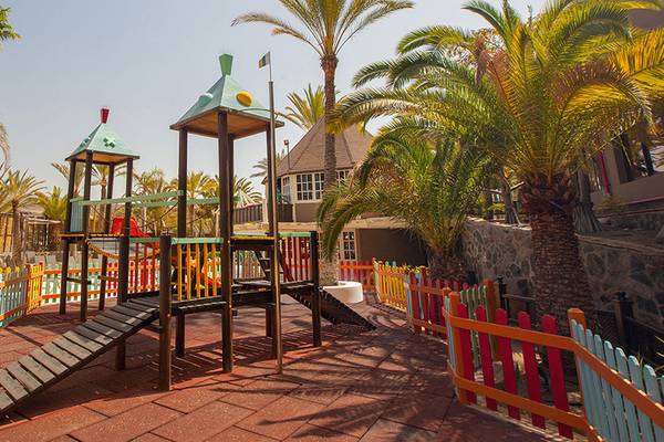 Spielplatz im Freien im Abora Continental by Lopesan Hotel mit bunten Zaun und Palmen
