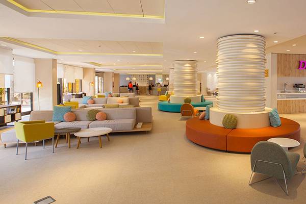 Lobby des Abora Continental by Lopesan Hotels mit bunten Sofas und Tischen.