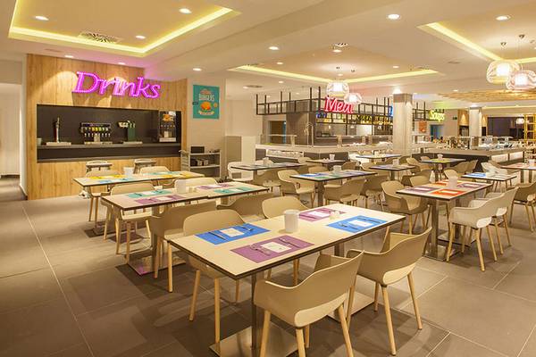 Innenansicht des Restaurants des Abora Continental by Lopesan Hotels mit Tischen und Stühlen, Beleuchtung und Neon-Schildern.