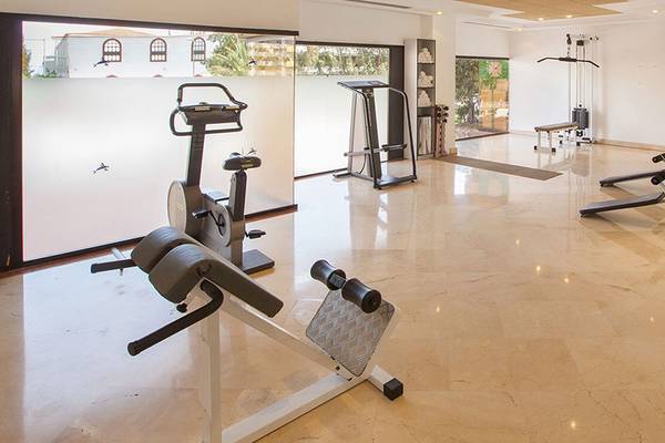 Fitnessbereich im Abora Continental by Lopesan Hotel mit verschiedenen Trainingsgeräten und Panoramafenstern.