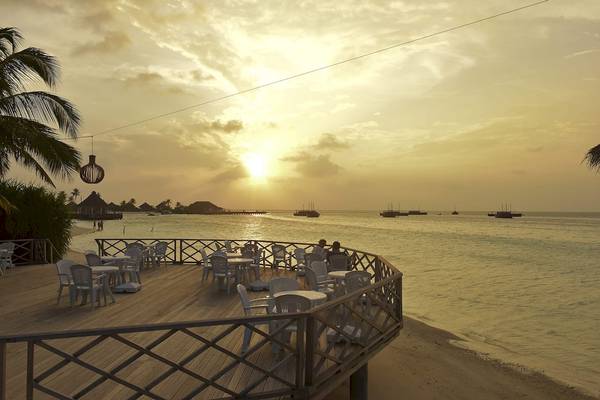 Terrasse des Safari Island Resorts mit Blick auf den Sonnenuntergang und das Meer.