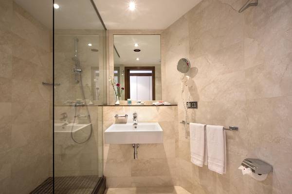 Badezimmer im Hipotels Cala Millor Park mit Dusche, Waschbecken und Toilettenpapierhalter.