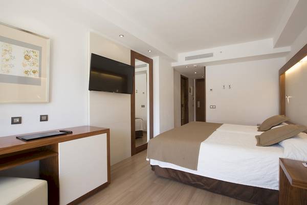 Doppelbettzimmer im Hipotels Cala Millor Park Hotel mit Fernseher und Schreibtisch.
