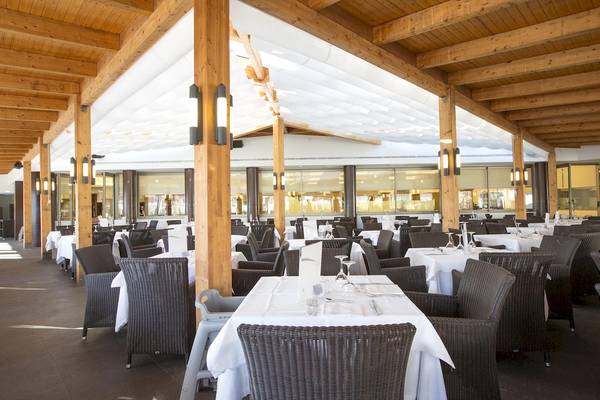 Innenansicht des Restaurants im Hipotels Cala Millor Park mit vielen gedeckten Tischen und Holzsäulen.
