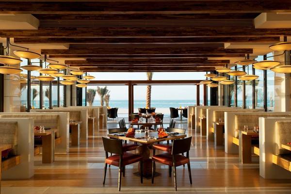 Innenansicht des Restaurants im St. Regis Saadiyat Island Resort mit Blick auf das Meer.