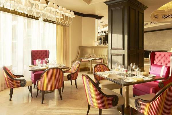 Innenansicht des Restaurants im St. Regis Saadiyat Island Resort mit bunten Stühlen und Tischen.