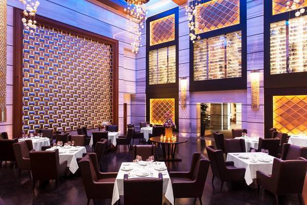 Restaurant-Interieur im St. Regis Saadiyat Island Resort mit eleganten Tischarrangements und luxuriösem Ambiente.