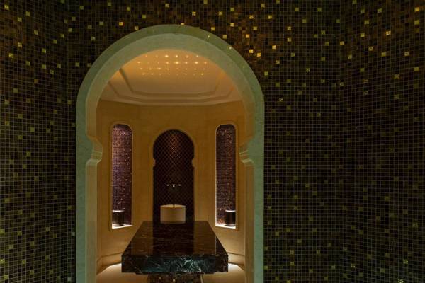 Inneneinrichtung des St. Regis Saadiyat Island Resort mit marmorner Theke und Mosaikwänden.