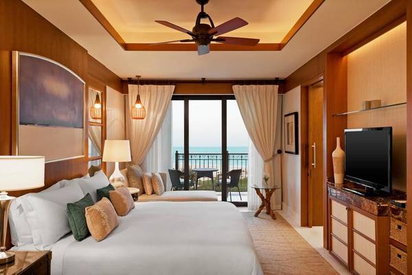 Schlafzimmer im St. Regis Saadiyat Island Resort mit Meerblick und Balkon.