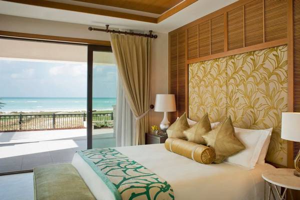 Hotelzimmer mit Meerblick im St. Regis Saadiyat Island Resort mit Bett, Kissen und Lampen