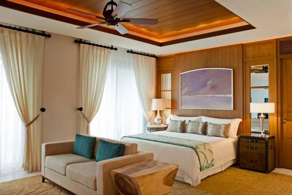 Schlafzimmer im St. Regis Saadiyat Island Resort mit Bett, Couch und Deckenventilator